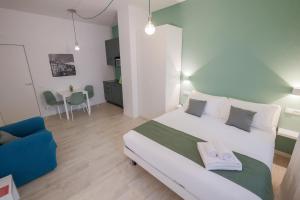 een slaapkamer met een groot wit bed en een blauwe bank bij Cà Cianfer in Bergamo