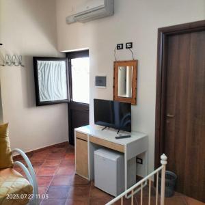 a room with a desk with a tv and a mirror at Bed and Breakfast Don Angelo Miramare in Realmonte