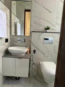 Un baño blanco con lavabo e inodoro. en Four season kasauli, en Kasauli