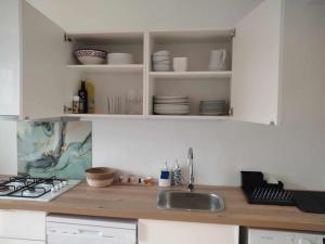 a kitchen with a sink and a counter top at L établissement Gold Beach propose 1 maison 80m2 avec terrain 500m2 PARKING PRIVE à 4 min du port artificiel d ARROMANCHES SERVICES Accueil personnalisé lits faits serviettes ménage NETFLIX wifi SUR VELOROUTE in Ryes