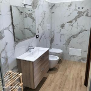 a bathroom with a sink and a toilet and a mirror at Bed and Breakfast Don Angelo Miramare in Realmonte