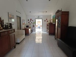 a large living room with a person walking through the doorway at Ndalem Mantrigawen in Yogyakarta