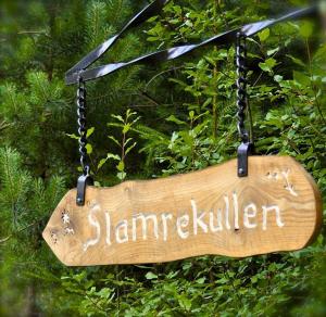 a wooden sign that reads jameliken hanging from a bush at Slamrekullen - Ullared in Ullared