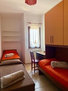 a bedroom with two beds and a desk and a window at La Corte del Principe in Bracciano