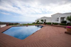 a house with a swimming pool in front of a house at Casa en primera linea en Binibeca Vell in Binibeca