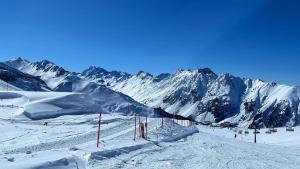 una pista de esquí con montañas cubiertas de nieve en el fondo en Ferienwohnung Malteser, en Nauders