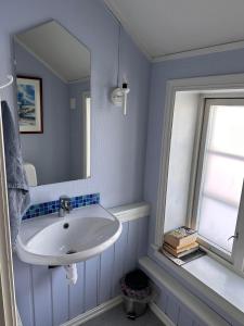 a bathroom with a sink and a mirror at Tidligere stall omgjort til koselig hjem i sentrum in Tromsø