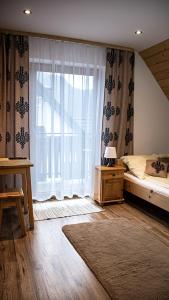 a bedroom with a bed and a large window at Krokus in Sromowce Niżne