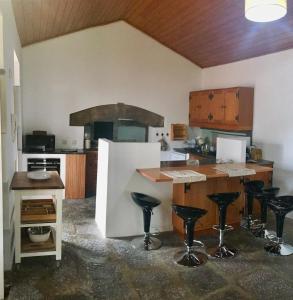 - une cuisine avec un comptoir et des tabourets dans une pièce dans l'établissement Casa do Pombal, à São Mateus