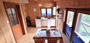 a kitchen with a table in a tiny house at Domki Letniskowe Las Palmas Dąbki in Dąbki