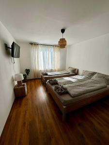 two beds in a room with wooden floors at Casa Anastasia in Dubova