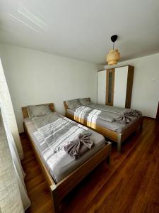 2 łóżka w pokoju z drewnianą podłogą w obiekcie Casa Anastasia w mieście Dubova