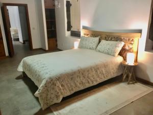 a bedroom with a large bed and two candles on tables at Casa do Pombal in São Mateus +29 photos