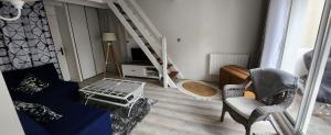 uma sala de estar com um sofá azul e uma escada em A 100m de la plage, Aperçu mer, wifi, 2 chambres, 2 salles de bains, 2WC em Saint-Georges-de-Didonne