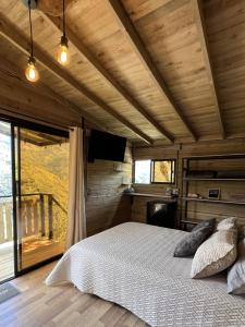 um quarto com uma cama e uma grande janela em La Peña Cabins en Ebéjico em Ebéjico
