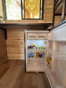 um frigorífico aberto cheio de muitas bebidas em La Peña Cabins en Ebéjico em Ebéjico