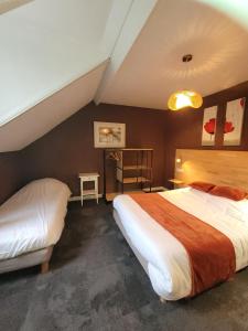 a hotel room with two beds and a table at Le petit Montmartre in Dinard