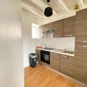 a kitchen with wooden cabinets and a sink at Studio Cosy et Lumineux à Etampes in Étampes