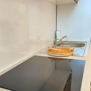 una cocina con fregadero y una cesta en un estante en Studio Cosy et Lumineux à Etampes, en Étampes
