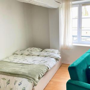 1 dormitorio con 1 cama y 1 sofá azul en Studio Cosy et Lumineux à Etampes, en Étampes