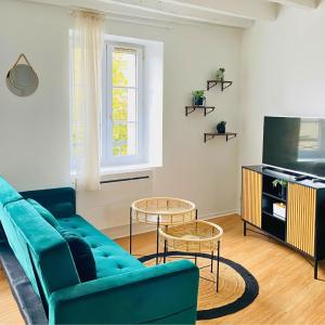 a living room with a blue couch and two tables at Studio Cosy et Lumineux à Etampes in Étampes