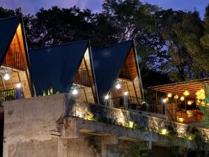 a house with a black roof and lights at Sundown Lake Hotel & Spa in Habarana