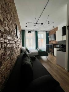 a living room with a bed against a brick wall at LOFT Słowackiego in Wałbrzych