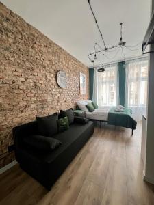 a living room with a couch and a brick wall at LOFT Słowackiego in Wałbrzych
