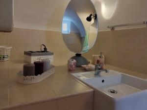 een badkamerbar met een wastafel en een spiegel bij House of roses in Ceglie Messapica