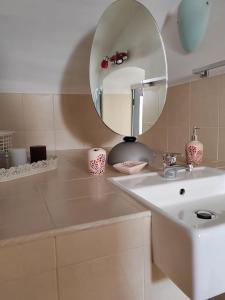 een badkamer met een wastafel en een spiegel bij House of roses in Ceglie Messapica
