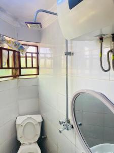 a bathroom with a toilet and a sink at Legends Castle Suites in Gwarinpa