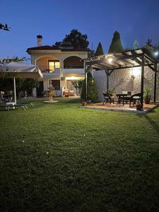 a house with a yard with picnic tables and umbrellas at Nikitihouse Apartments 2 in Nikiti