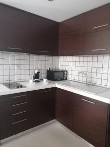 a kitchen with brown cabinets and a white counter top at Nikitihouse Apartments 2 in Nikiti