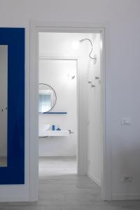 een witte badkamer met een wastafel en een spiegel bij Cà Cianfer in Bergamo