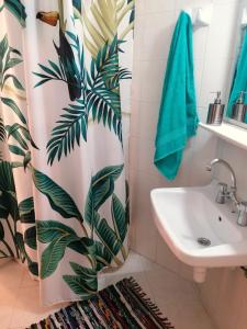 a bathroom with a shower curtain and a sink at Nikos Apartments 2 in Kavos