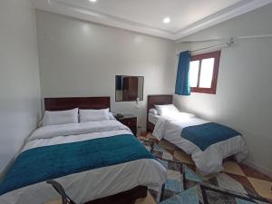 1 Schlafzimmer mit 2 Betten und einem Fenster in der Unterkunft Dream Hotel in Qinā