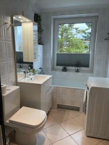 baño con aseo y lavabo y ventana en Apartament Sweet Home Cieplice SPA, en Jelenia Góra