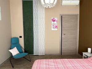 a bedroom with a bed and a blue chair at Pole Position Rho Milano - Top to reach City centre, Exhibition, Mind, Live Dome, San Siro in Rho