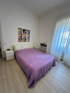 um quarto com uma cama grande e um cobertor roxo em Appartamento incantevole con patio em Florença