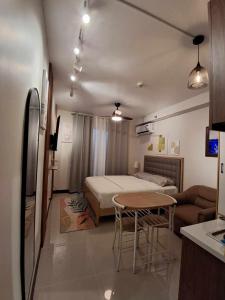 a room with a bed and a table and a couch at New Cozy Studio Apartment in Marigondon
