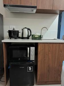 Il comprend une cuisine équipée d'un four micro-ondes et d'une cuisinière. dans l'établissement New Cozy Studio Apartment, à Marigondon