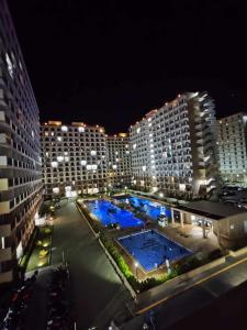 - une vue sur la ville la nuit avec 2 piscines dans l'établissement New Cozy Studio Apartment, à Marigondon