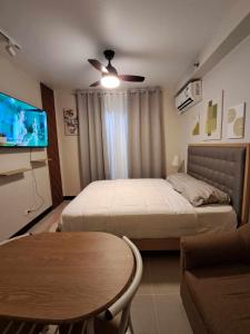 - une chambre avec un lit, une télévision et une table dans l'établissement New Cozy Studio Apartment, à Marigondon