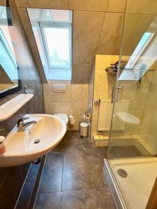 a bathroom with a sink and a shower at Pension Kolibri in Hemmoor