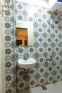 een badkamer met een wastafel en een spiegel bij Nusmile home & travel 22 hang Non, Old town in Hanoi