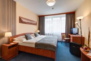 オストラヴァにあるLC - Hotel Ostravaのベッドとデスクが備わるホテルルームです。