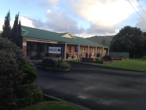 a building with a green roof on a street at Beachcomber Motel & Apartments in Apollo Bay