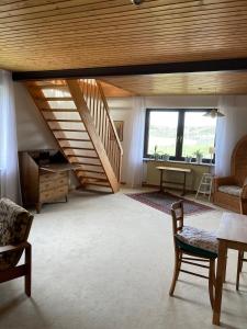 a living room with a staircase and a table and chairs at Ferienwohnung Frangenberg in Lindlar