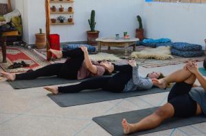 a group of women laying on the floor in a yoga class at Surf Therapy Morocco in Agadir