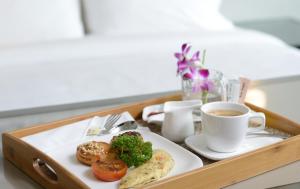 a tray with a plate of food and a cup of coffee at Olive Tree Hotel Penang in Bayan Lepas